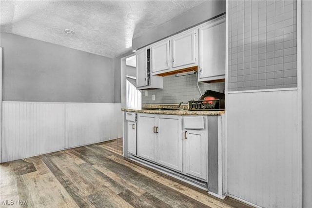 kitchen featuring white cabinetry, a textured ceiling, dark hardwood / wood-style flooring, and decorative backsplash