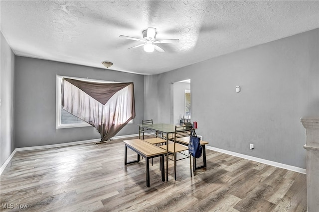 dining space featuring a textured ceiling, ceiling fan, and hardwood / wood-style flooring