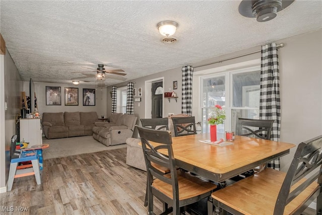 dining room featuring a textured ceiling, ceiling fan, and light hardwood / wood-style floors