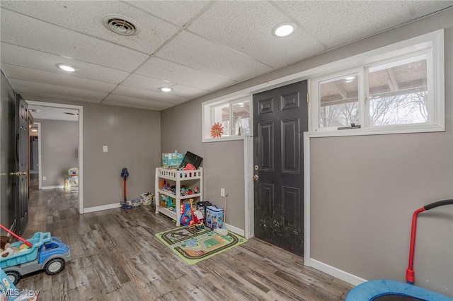 playroom featuring hardwood / wood-style flooring and a drop ceiling