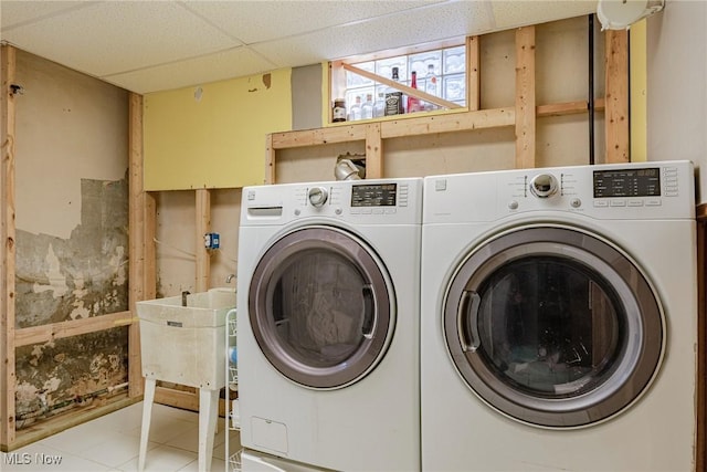 clothes washing area featuring washing machine and dryer, sink, and light tile patterned flooring