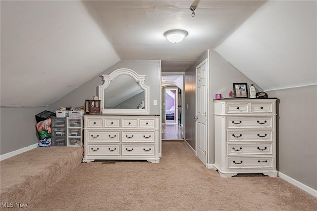 additional living space featuring lofted ceiling and light colored carpet