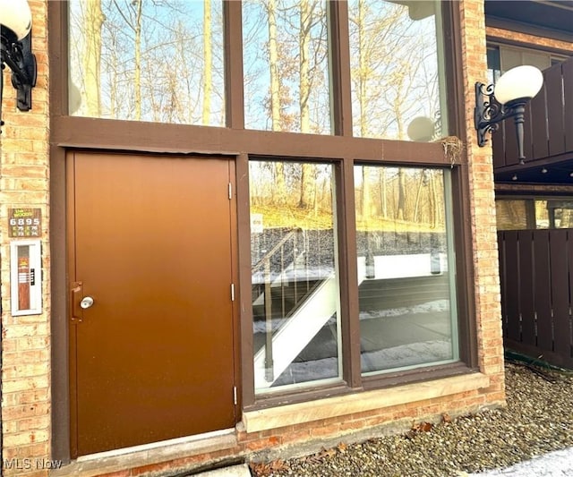 doorway to outside featuring brick wall