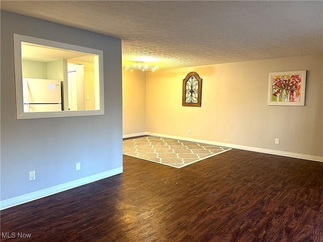 empty room featuring a textured ceiling and dark hardwood / wood-style floors