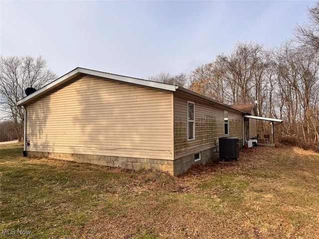 view of property exterior with central air condition unit and a yard