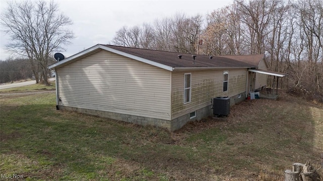 view of property exterior with central AC unit and a lawn