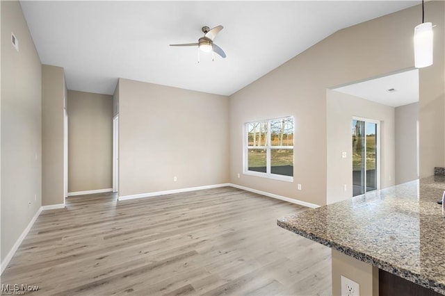 unfurnished living room featuring visible vents, baseboards, lofted ceiling, light wood-style flooring, and ceiling fan