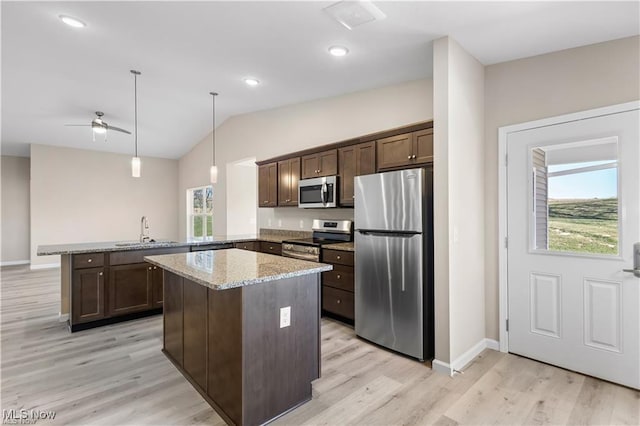 kitchen with dark brown cabinetry, a peninsula, a sink, appliances with stainless steel finishes, and pendant lighting