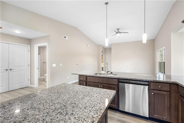 kitchen with dishwasher, hanging light fixtures, light stone countertops, vaulted ceiling, and a sink