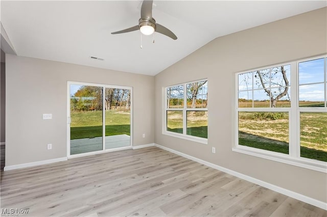 empty room featuring vaulted ceiling, baseboards, visible vents, and light wood-style floors