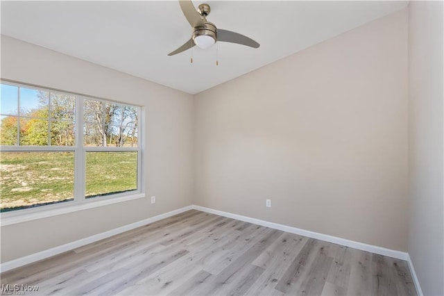 empty room featuring ceiling fan, light wood-style floors, and baseboards