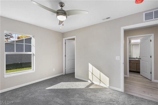 unfurnished bedroom with carpet flooring, visible vents, and baseboards