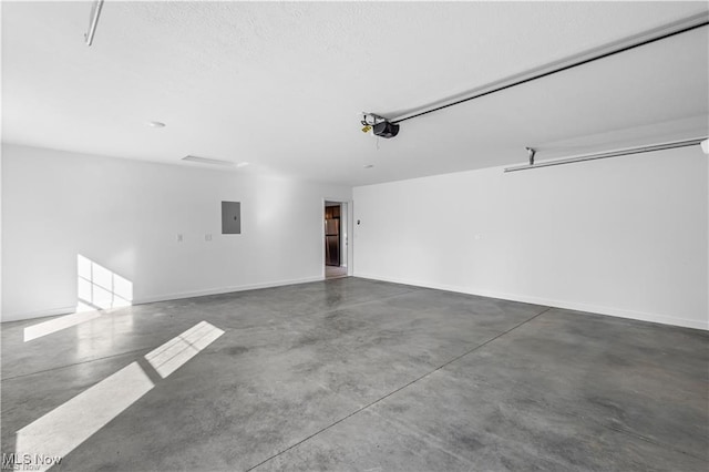 garage with baseboards, electric panel, and a garage door opener