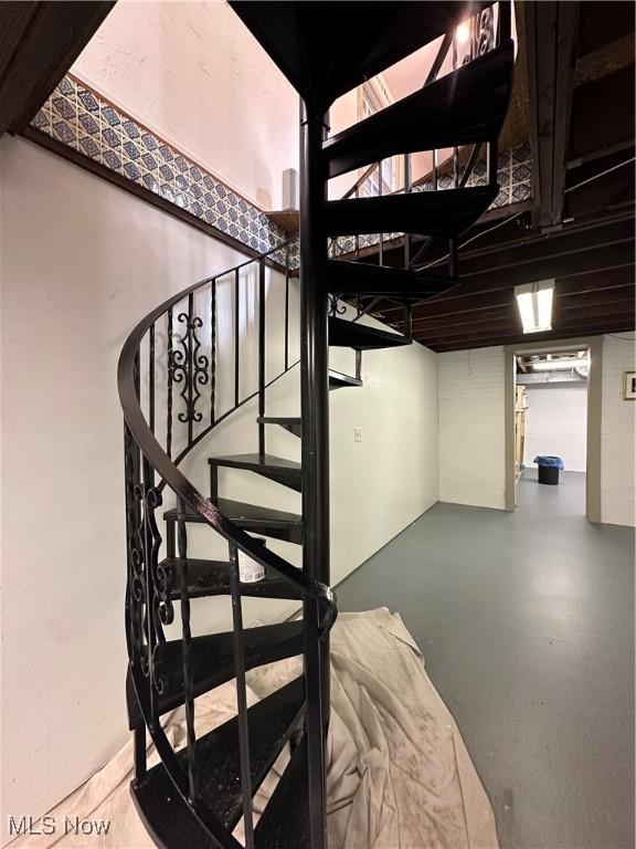 staircase featuring finished concrete floors