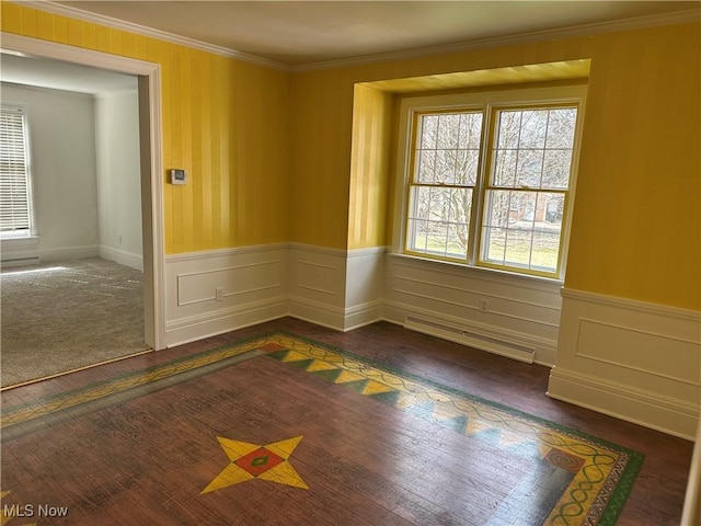 unfurnished room featuring crown molding, wainscoting, visible vents, and dark wood-type flooring