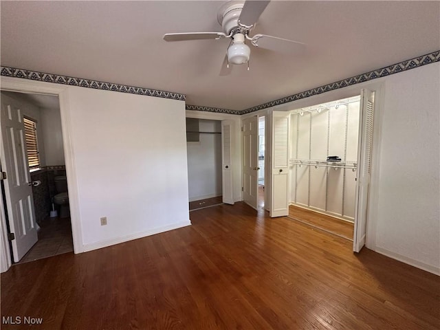 unfurnished bedroom featuring baseboards, ceiling fan, connected bathroom, and wood finished floors