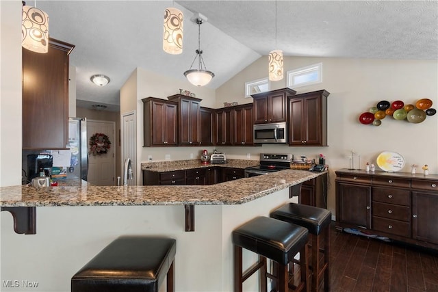 kitchen featuring dark brown cabinetry, appliances with stainless steel finishes, light stone counters, dark wood-style flooring, and decorative light fixtures