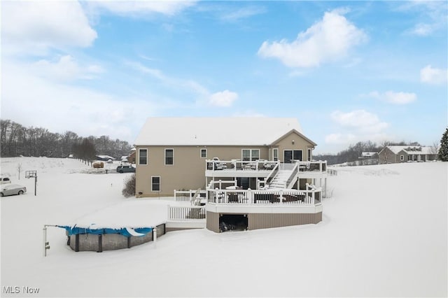 snow covered property featuring stairs and a deck