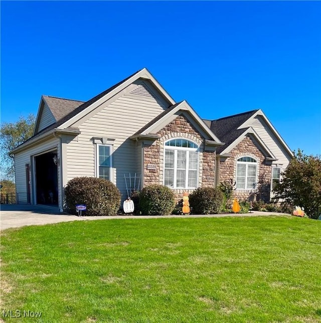 ranch-style home with a garage, stone siding, a front yard, and driveway