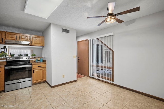 kitchen with visible vents, light countertops, a textured ceiling, stainless steel range with electric cooktop, and under cabinet range hood