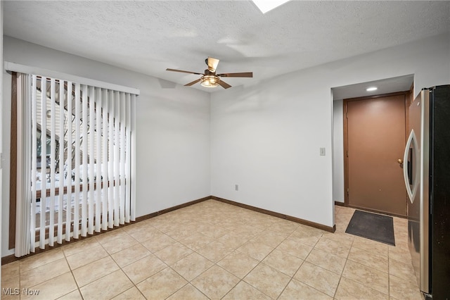 unfurnished room featuring ceiling fan, a textured ceiling, and baseboards