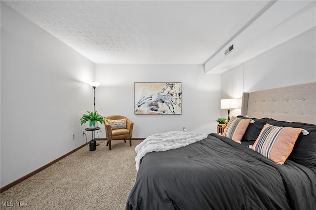 carpeted bedroom featuring baseboards, visible vents, and a textured ceiling