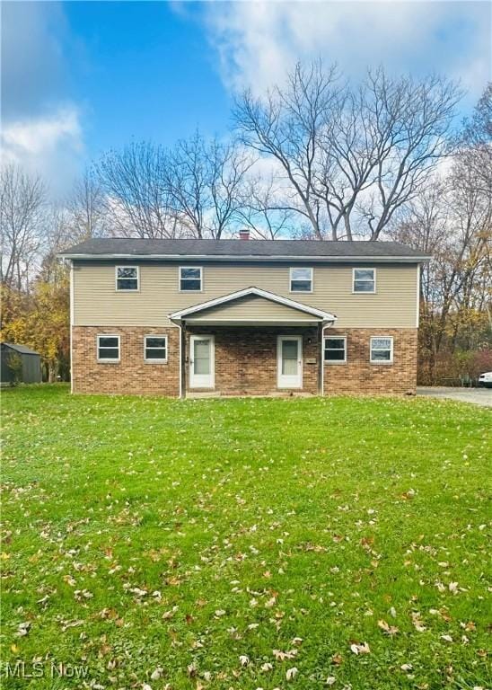 view of front of home with a chimney and a front yard