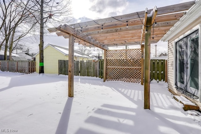 snow covered patio with fence and a pergola