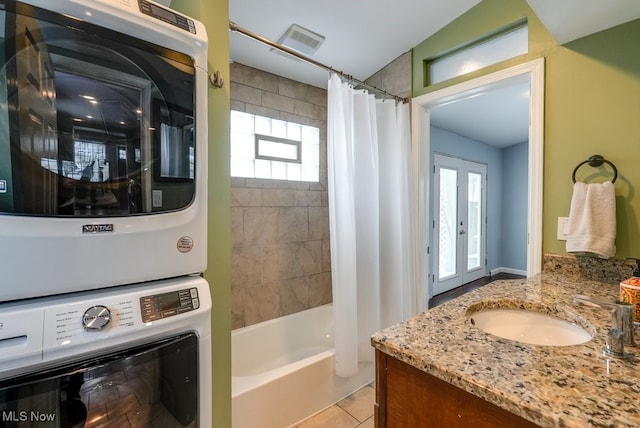 full bathroom featuring tile patterned flooring, shower / tub combo, visible vents, vanity, and stacked washer / drying machine