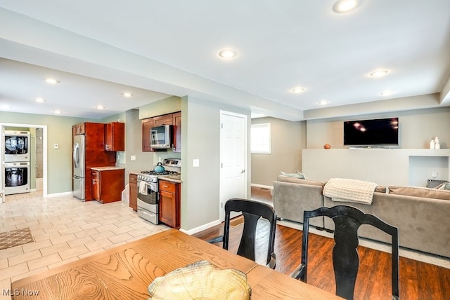 kitchen featuring appliances with stainless steel finishes, open floor plan, light countertops, dark brown cabinets, and recessed lighting