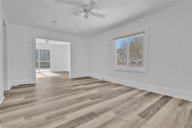 empty room featuring a ceiling fan, light wood-style flooring, and baseboards