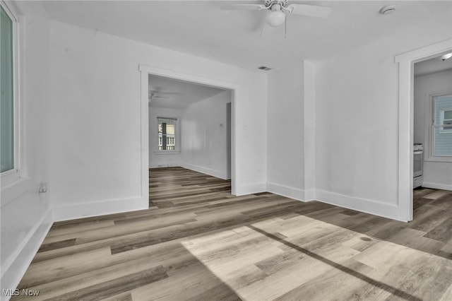 unfurnished room with baseboards, ceiling fan, visible vents, and wood finished floors