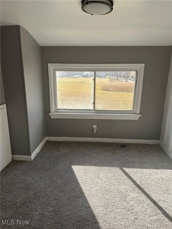 spare room featuring carpet and baseboards