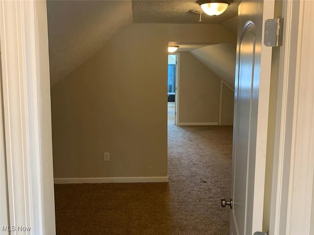 bonus room featuring vaulted ceiling, dark carpet, and baseboards