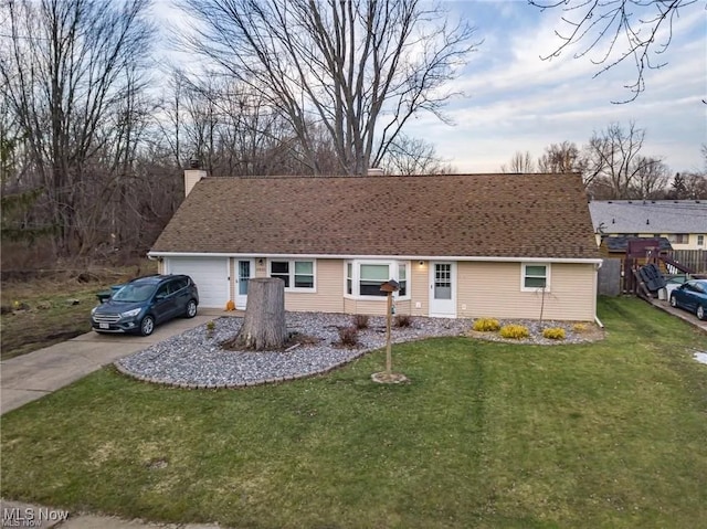 ranch-style house featuring a garage, a shingled roof, concrete driveway, a chimney, and a front yard