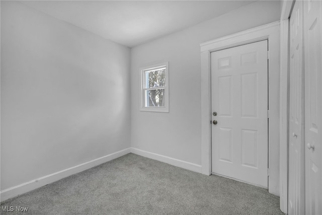 empty room with light colored carpet and baseboards