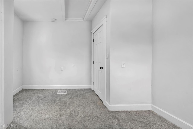 empty room featuring visible vents, baseboards, and carpet flooring