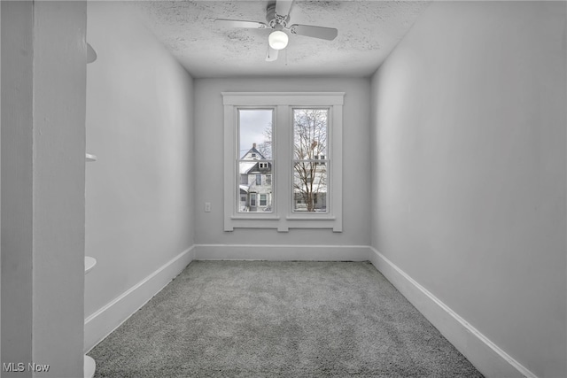 unfurnished room featuring carpet, baseboards, ceiling fan, and a textured ceiling