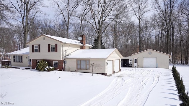 split level home with an outbuilding, brick siding, a chimney, and a garage