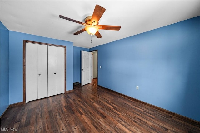 unfurnished bedroom featuring dark wood-style floors, a closet, ceiling fan, and baseboards