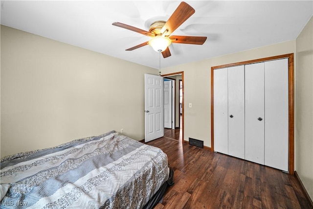 bedroom featuring ceiling fan, dark wood-type flooring, a closet, and baseboards