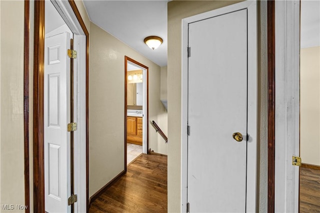 corridor featuring dark wood-style floors and an upstairs landing