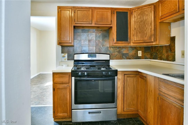 kitchen featuring light countertops, brown cabinetry, and gas stove