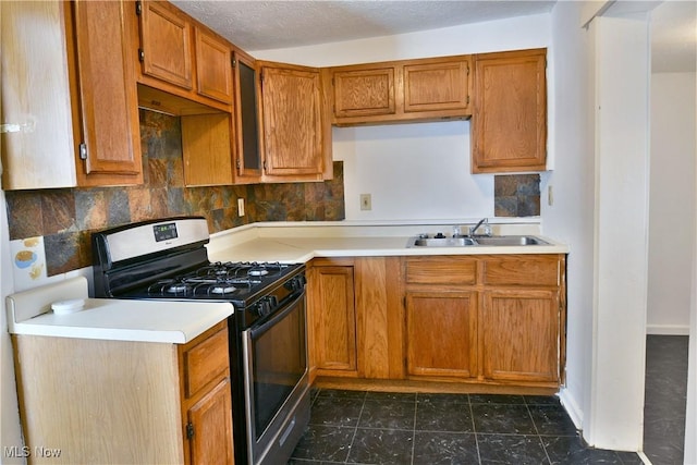 kitchen with light countertops, gas range oven, a sink, and brown cabinets