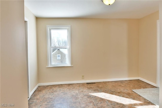 unfurnished room featuring visible vents and baseboards