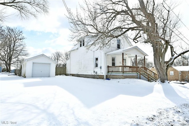 view of front of home with a garage, a porch, and an outdoor structure