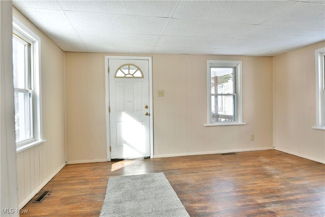 entrance foyer with dark wood-type flooring, a paneled ceiling, visible vents, and baseboards