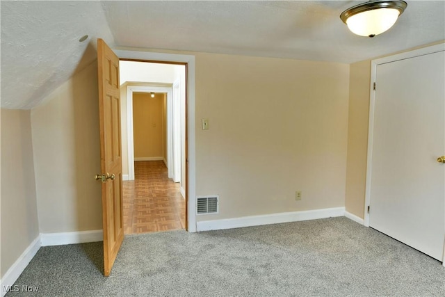 additional living space with lofted ceiling, carpet, visible vents, and baseboards