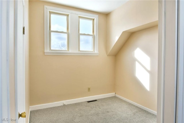 additional living space featuring light colored carpet, visible vents, and baseboards