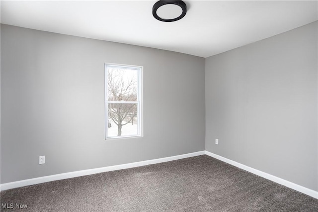 unfurnished room with carpet flooring and baseboards